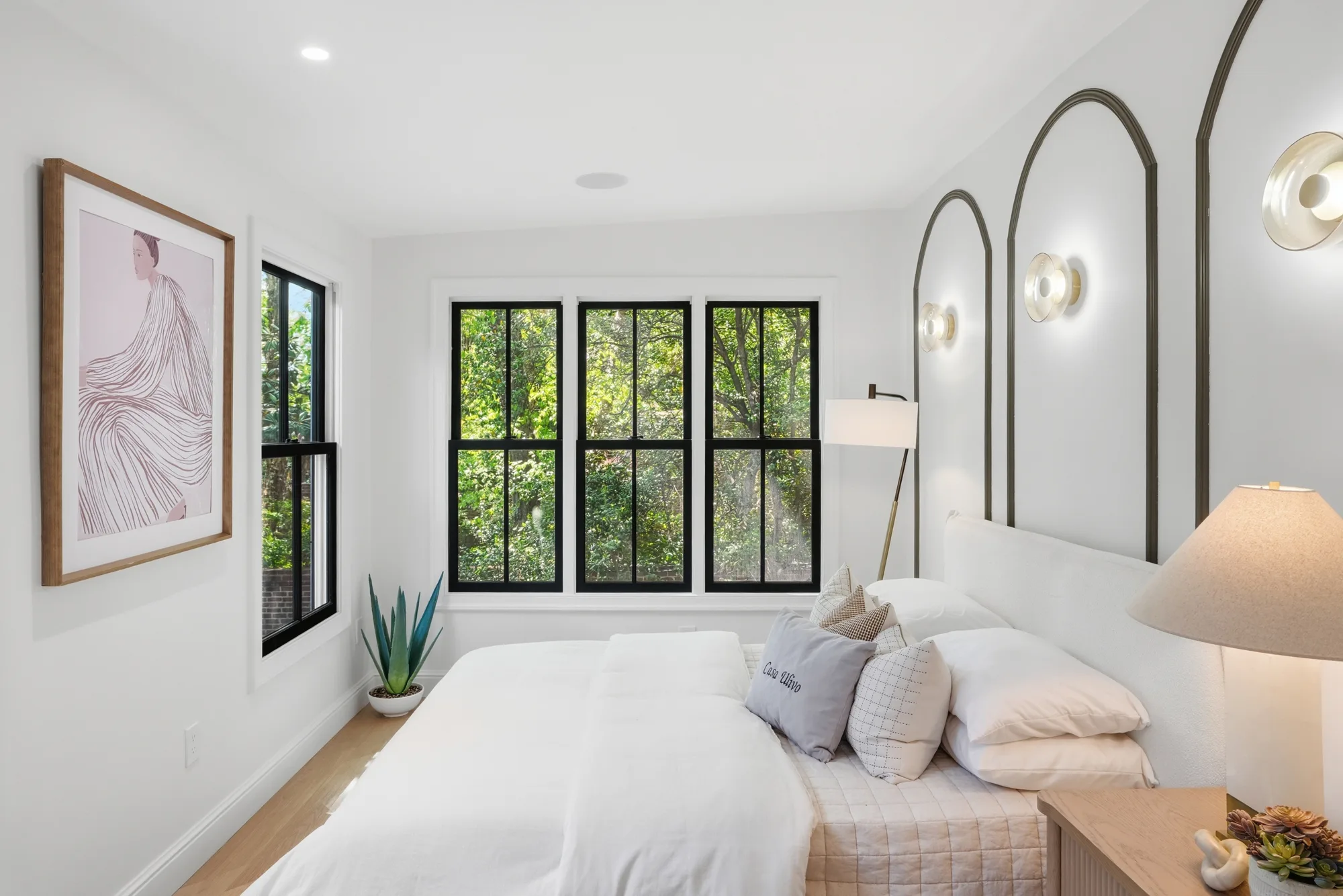 Bedroom with arched niches and sculptural sconces at Casa Ulivo