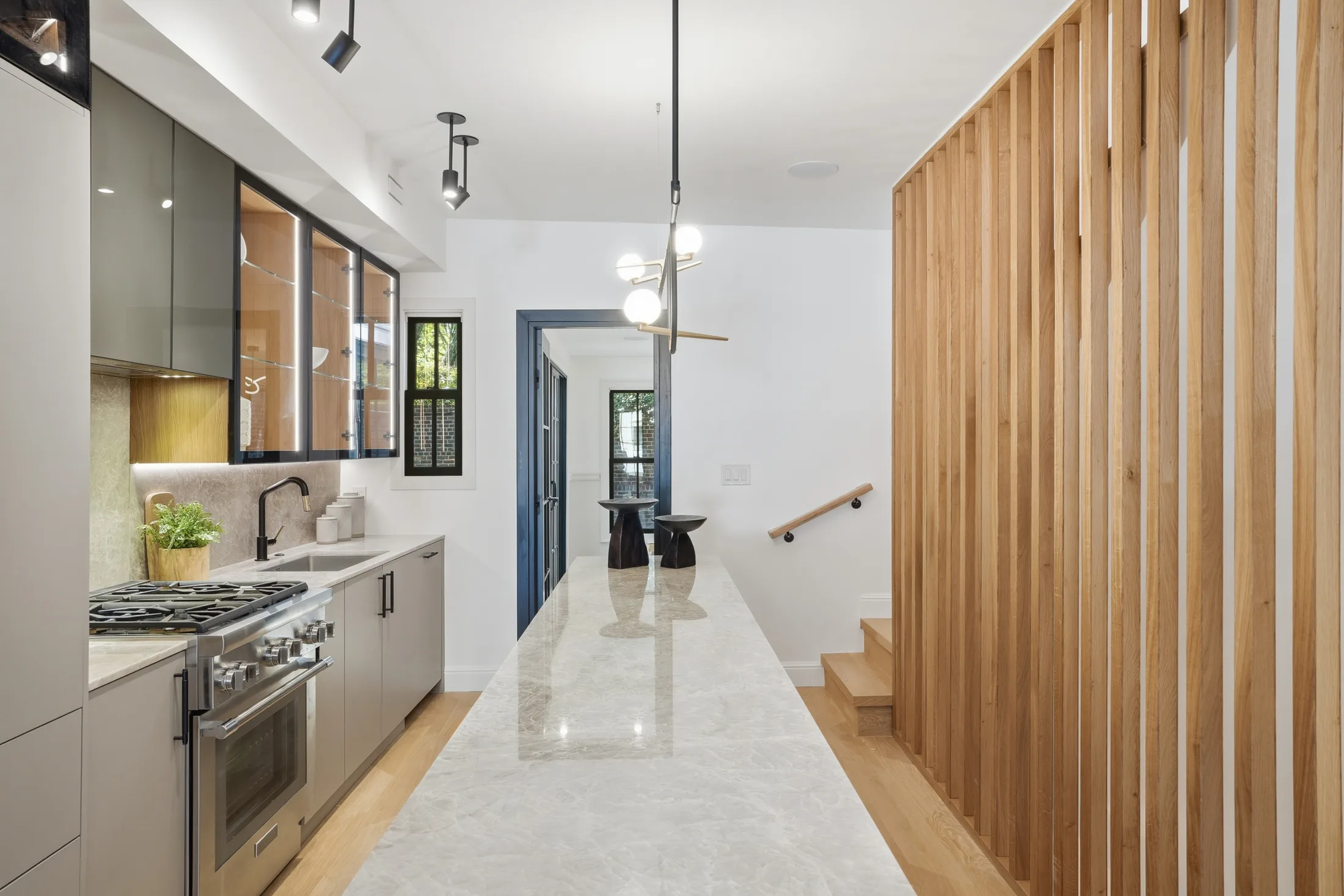Long view of the quartzite island beside a slatted oak screen at Casa Ulivo